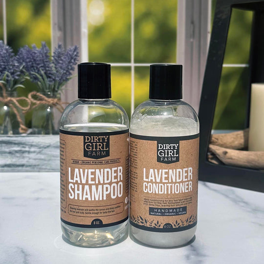 Dirty Girl Farm Lavender Shampoo and Conditioner on a counter with lavender and a candle